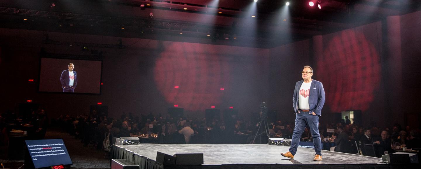 man giving a speech on a stage