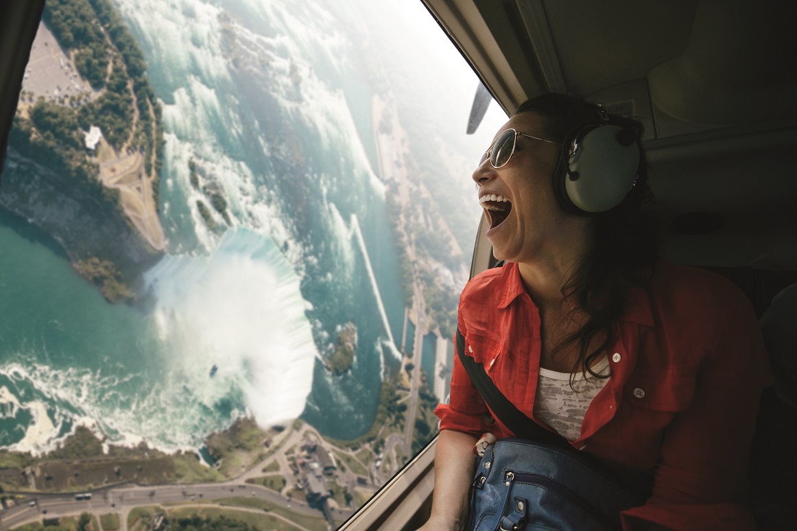 Person flying in helicopter over Niagara Falls