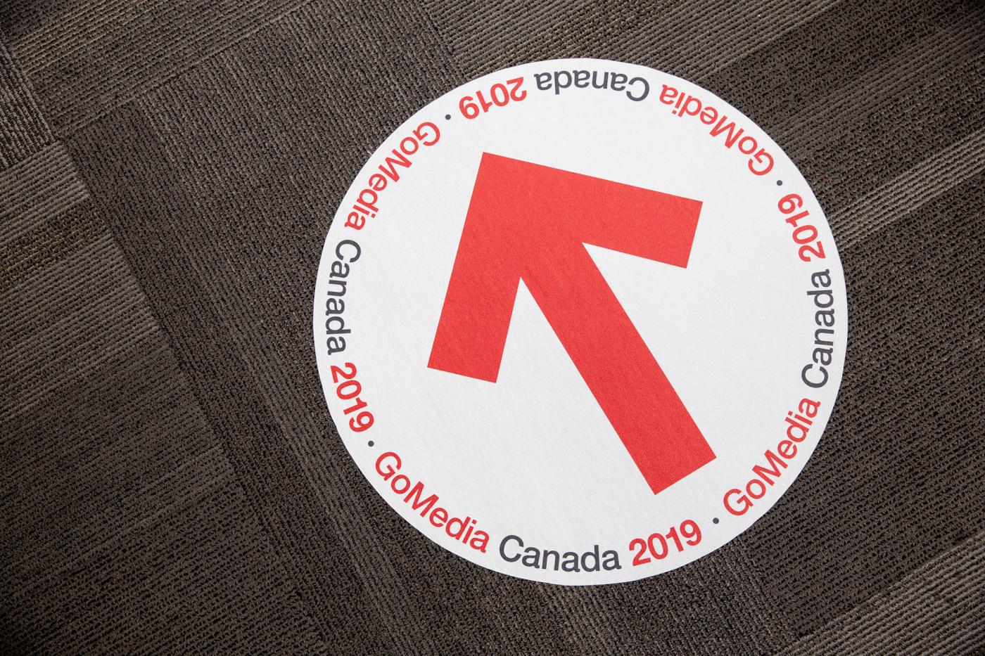 A floor decal showing a large red arrow and the event logo.