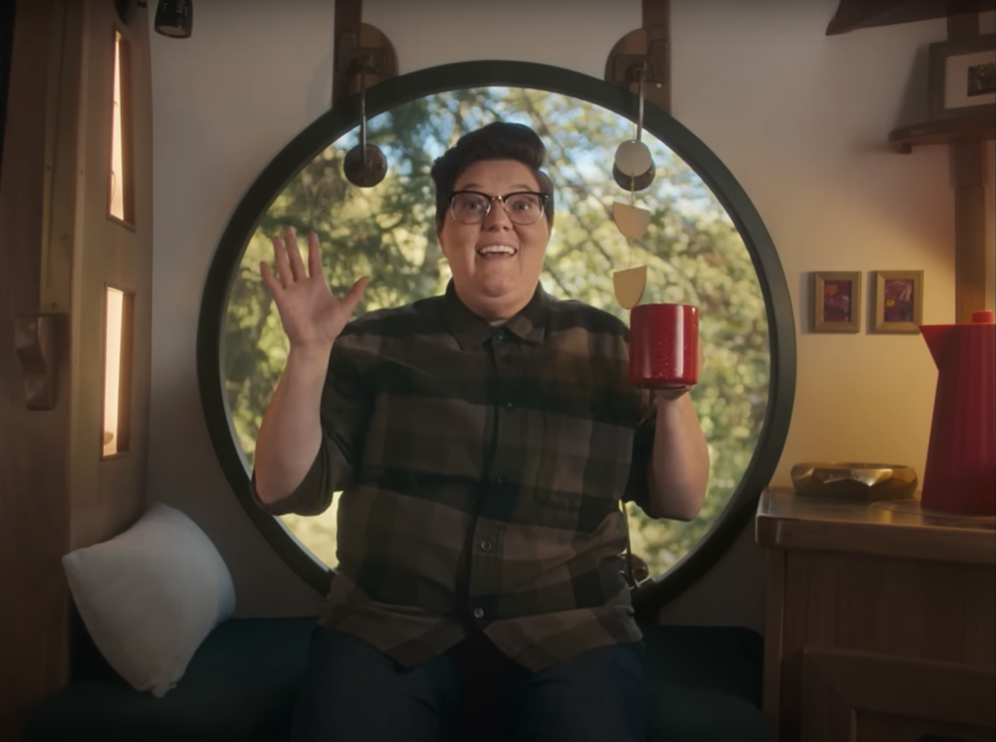 A screenshot of part of the Maple Leave video where a speaker is exclaiming in front of a circular window while holding a red coffee mug.