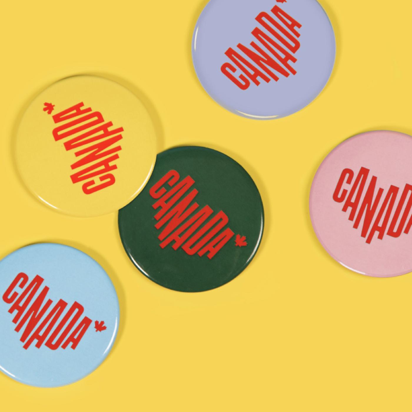 Five circular pins are scattered on a yellow background, each of the pins is a different solid colour with a red Canada logo centered in the middle.