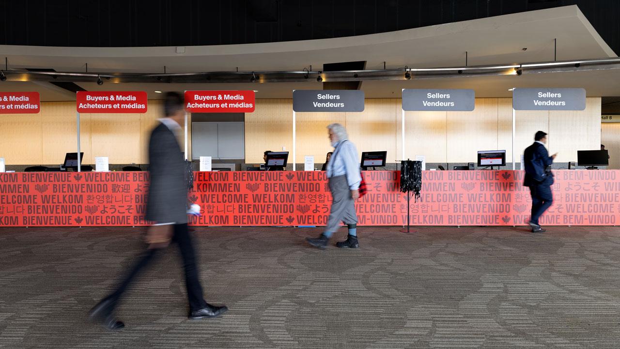 People walking past several Canada-branded registration booths