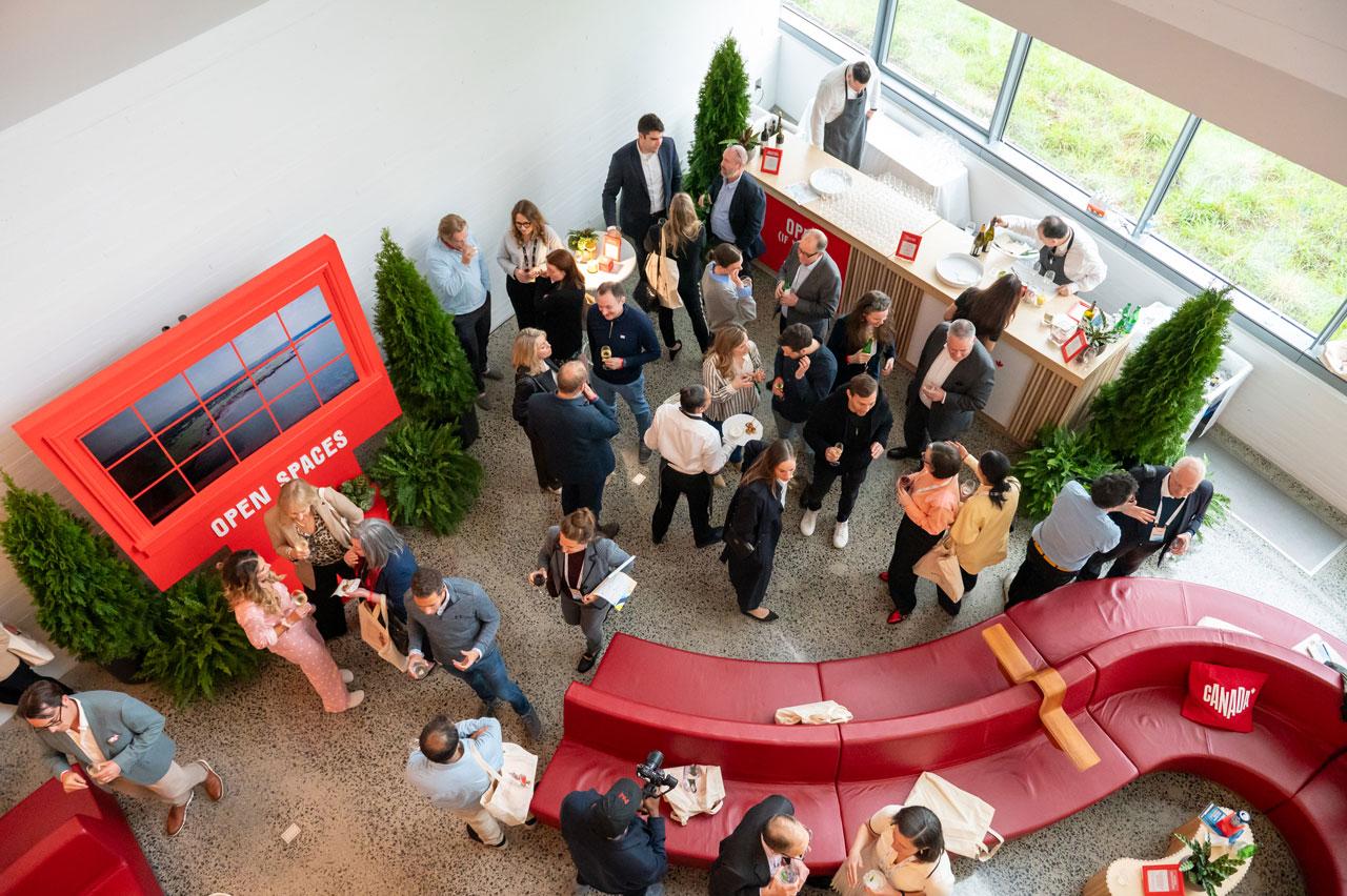 An overhead view of a networking event in a modern venue, featuring guests socializing around a curved red seating area