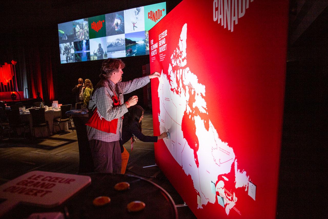 A person interacting with a large map of Canada