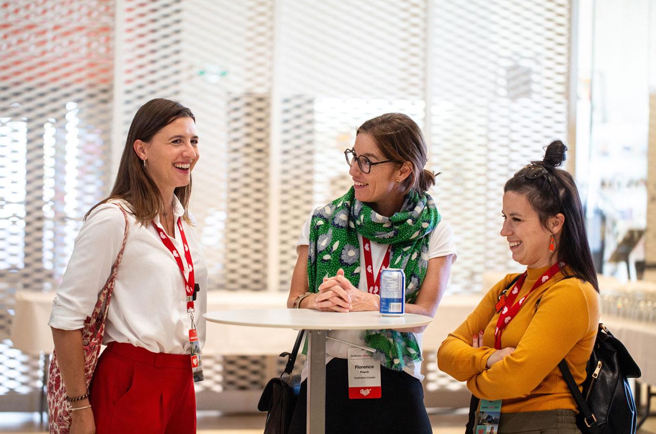 Three people at a table wearing Destination Canada branded lanyards