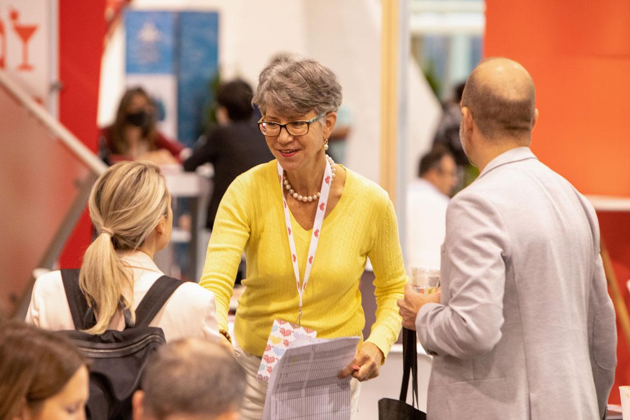 A person wearing a Destination Canada branded lanyard greeting guests