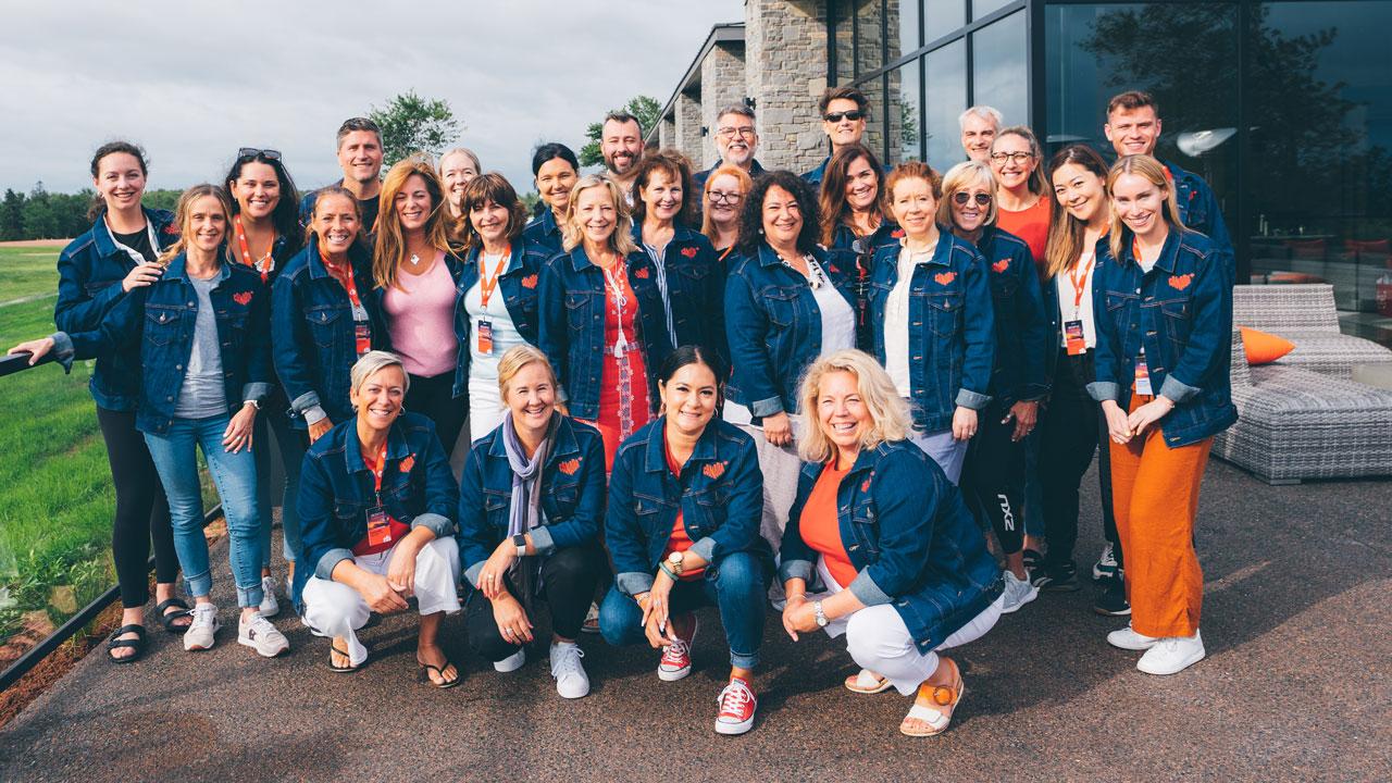A group photo outside, wearing matching Canada branded denim jackets