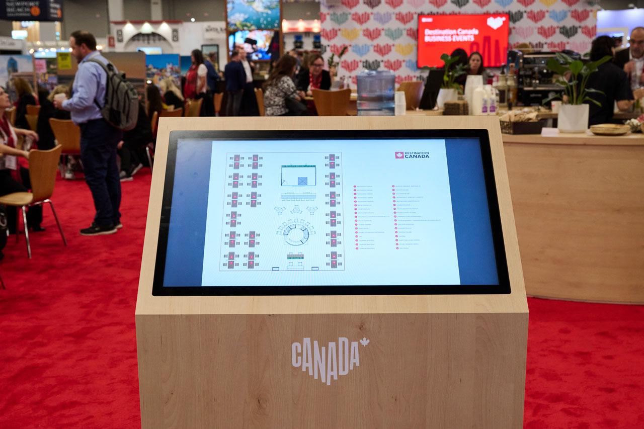 A digital wayfinding guide on a wooden podium