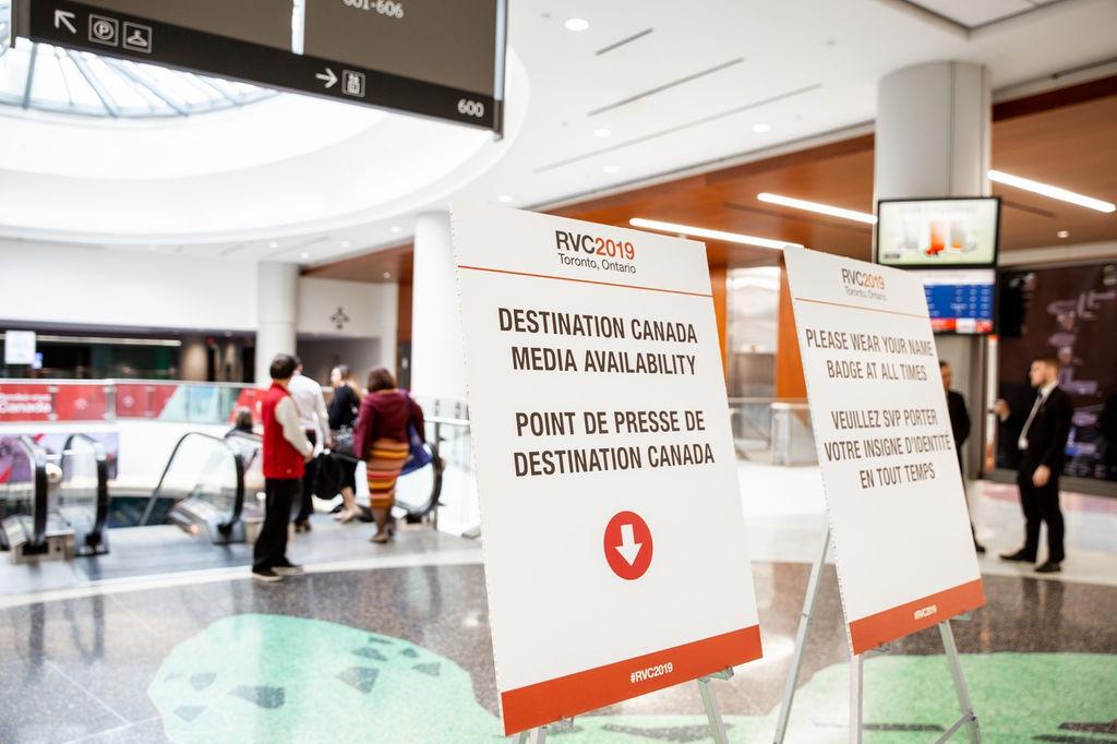 A sign at RVC 2019 Toronto with an arrow guiding to the Destination Canada media availability